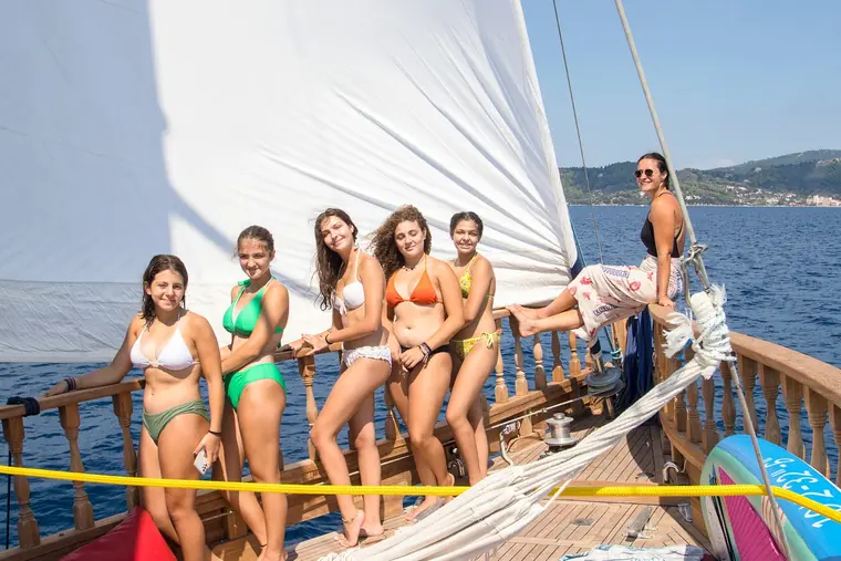 A group photo by the sail