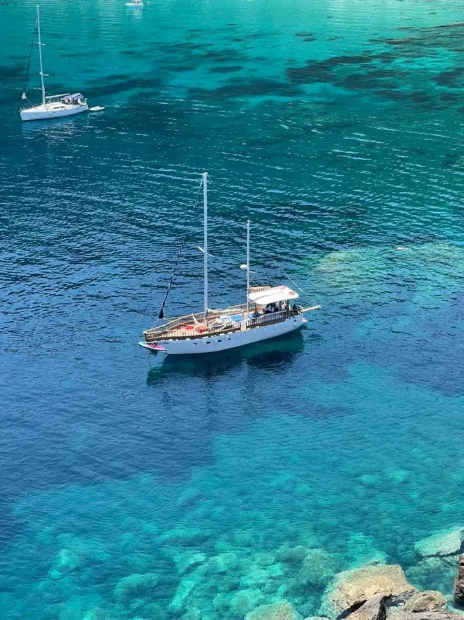 Nireas at anchor in turquoise water
