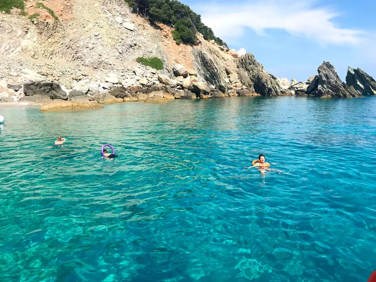 Swimming by a rocky headland